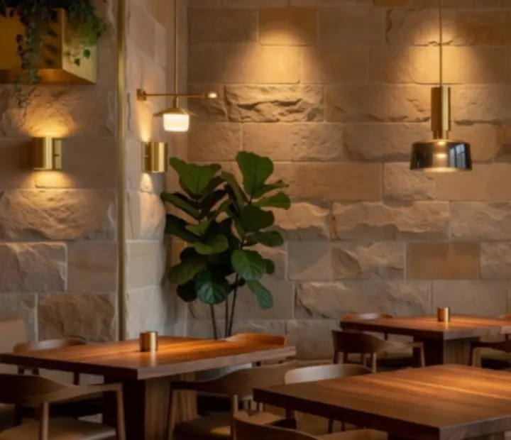Interior design detail with sandstone, hardwood, brushed brass and indoor greenery